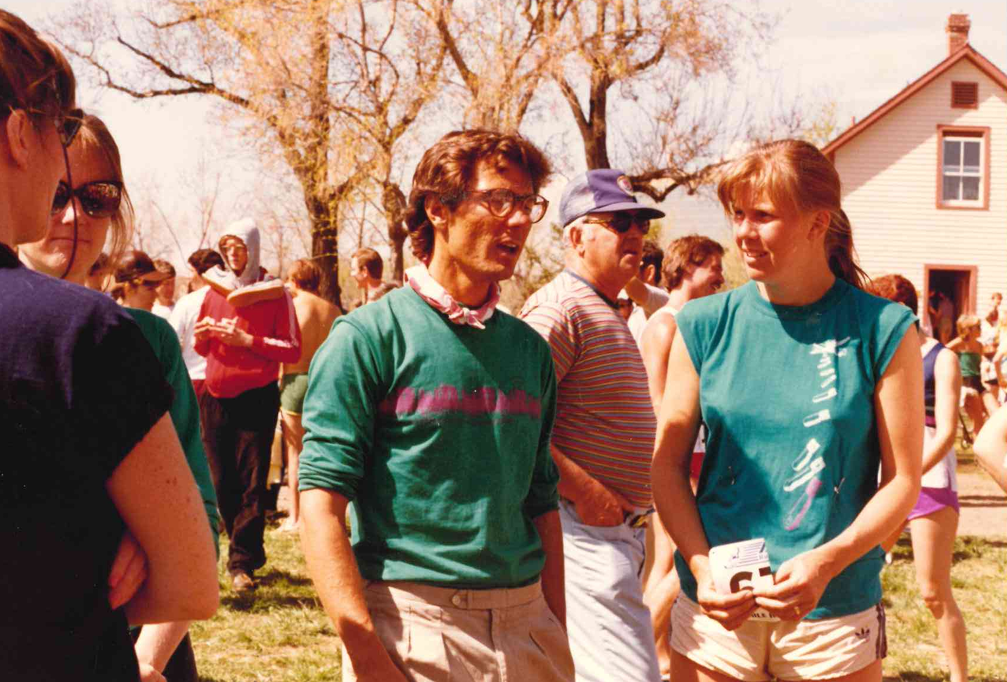 Un grupo de personas charlando al aire libre durante un evento soleado, con una casa al fondo