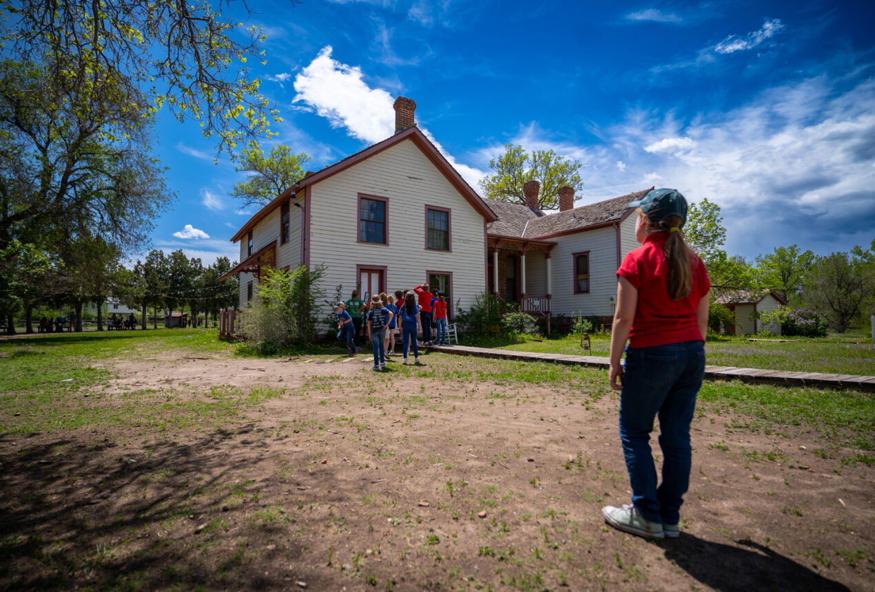 Un grupo posando frente a una casa histórica bajo un cielo azul intenso