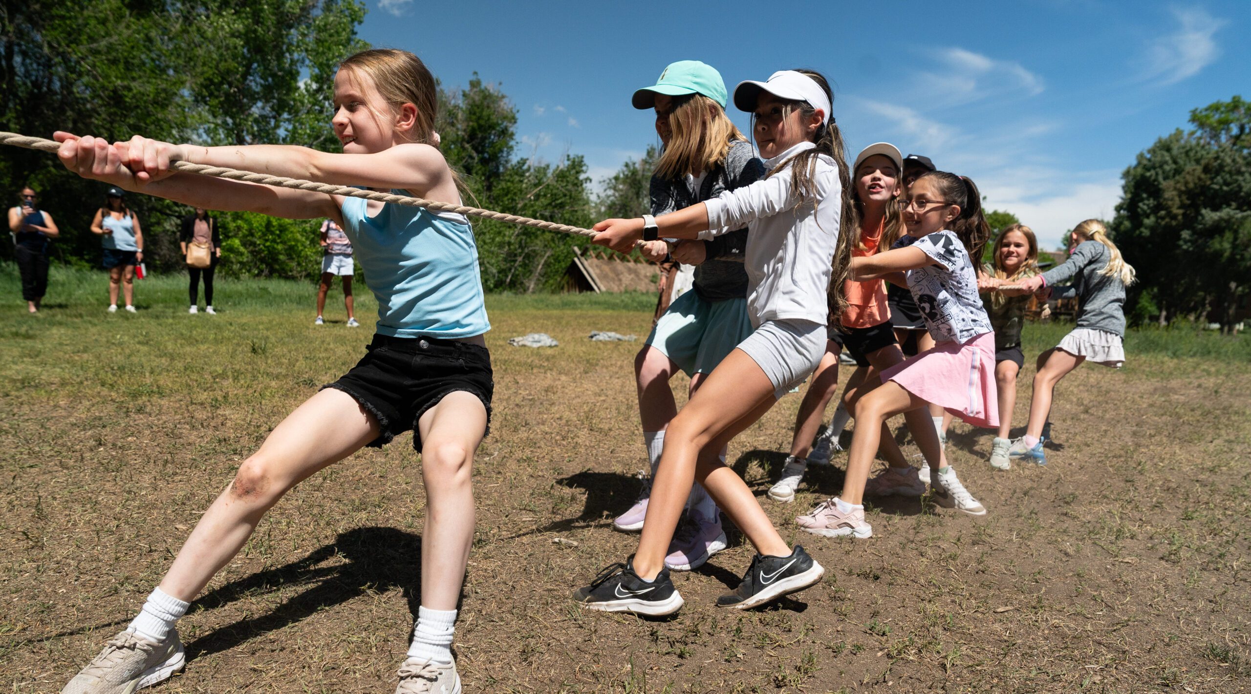 Children enthusiastically playing tug-of-war outdoors during the May 2025 Wagon Wheels Event